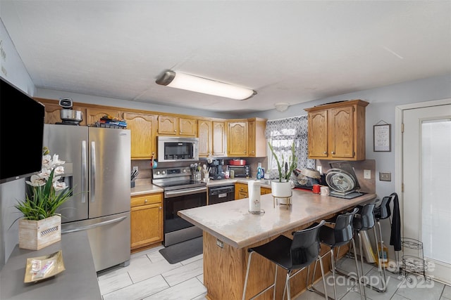 kitchen featuring light tile patterned floors, a kitchen breakfast bar, stainless steel appliances, and kitchen peninsula