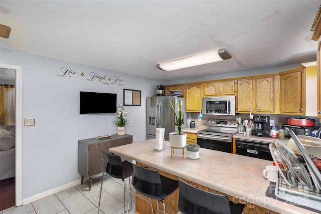 kitchen featuring appliances with stainless steel finishes, light tile patterned floors, and a kitchen breakfast bar