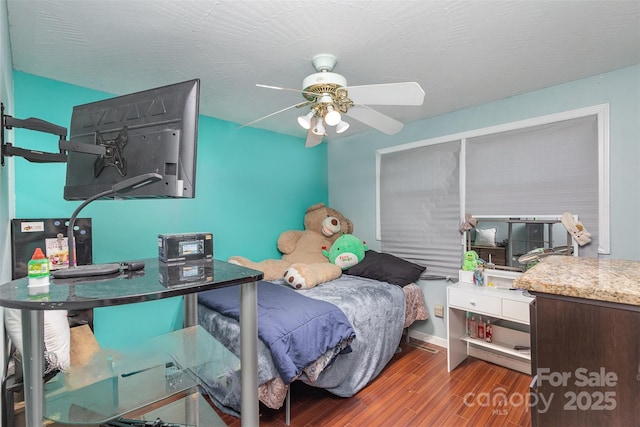 bedroom with dark hardwood / wood-style flooring and ceiling fan