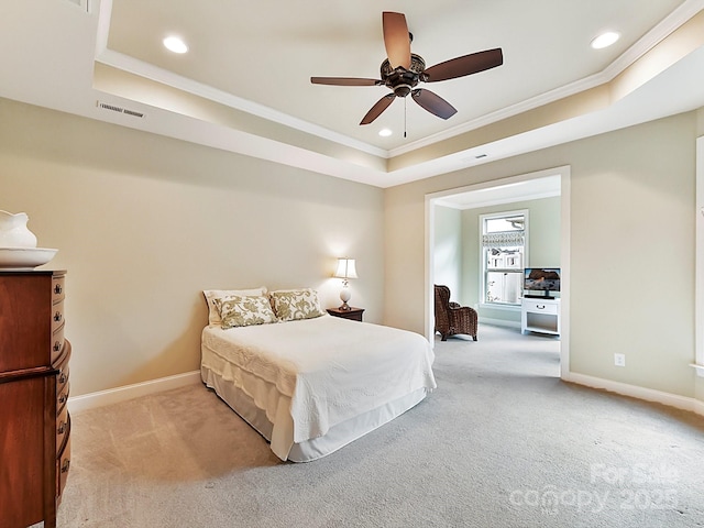 carpeted bedroom with ornamental molding, a raised ceiling, and ceiling fan