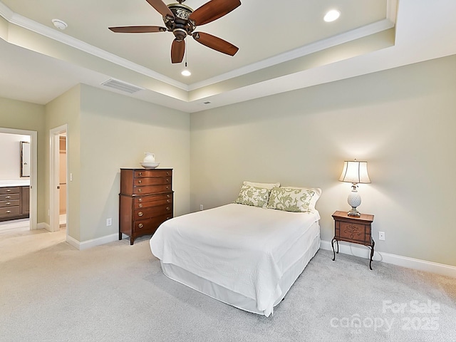 carpeted bedroom with a raised ceiling, ornamental molding, ceiling fan, and ensuite bath