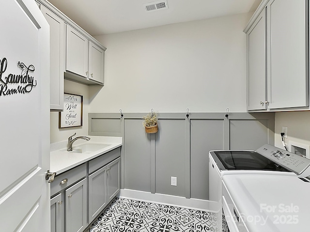 laundry room featuring cabinets, washing machine and dryer, and sink