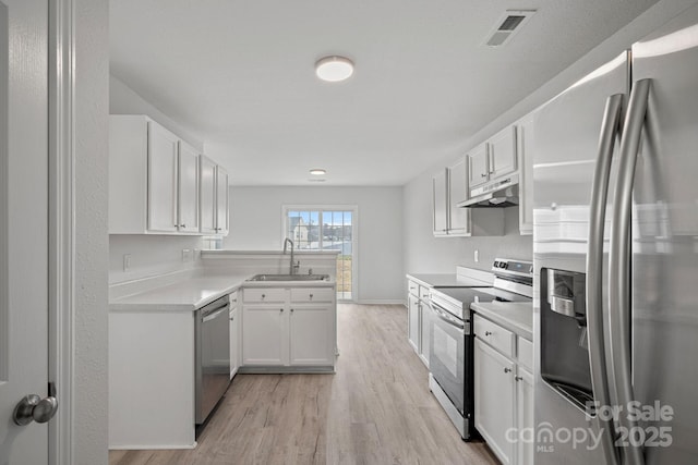 kitchen featuring sink, white cabinets, light wood-type flooring, and appliances with stainless steel finishes