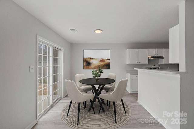 dining space with light hardwood / wood-style floors