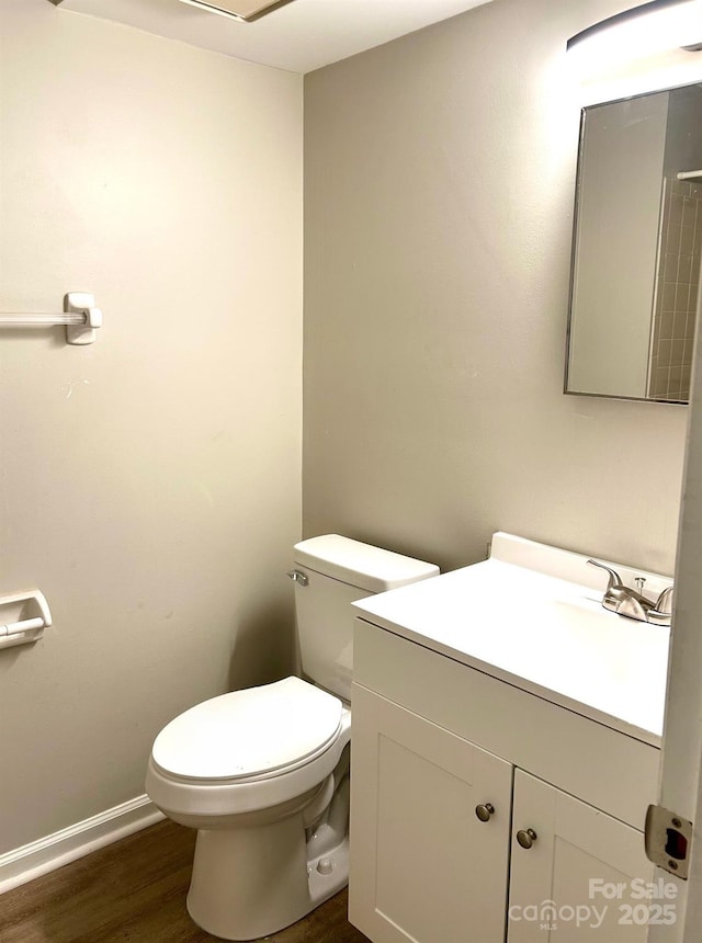 bathroom featuring wood-type flooring, vanity, and toilet