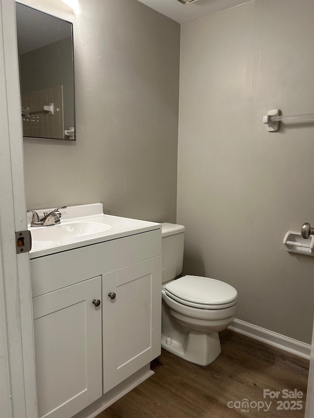 bathroom with vanity, hardwood / wood-style floors, and toilet