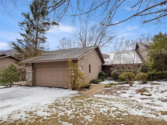 snow covered property featuring a garage