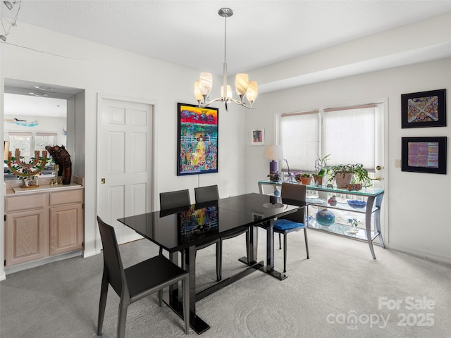 carpeted dining room featuring an inviting chandelier