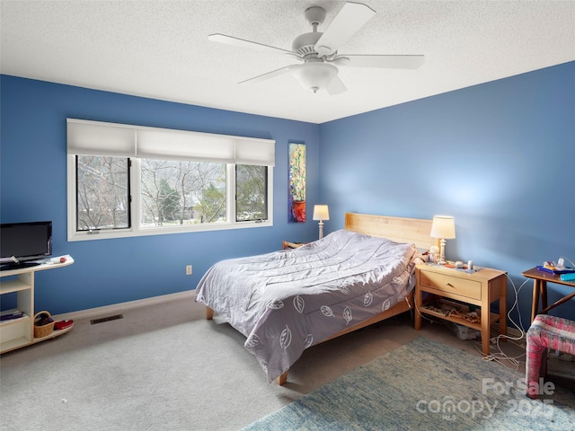 carpeted bedroom featuring a textured ceiling and ceiling fan