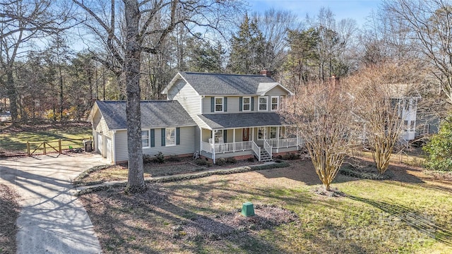 view of front facade with covered porch, a front lawn, and a garage