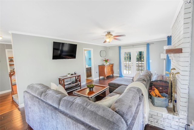 living room featuring a brick fireplace, ceiling fan, dark hardwood / wood-style floors, french doors, and crown molding