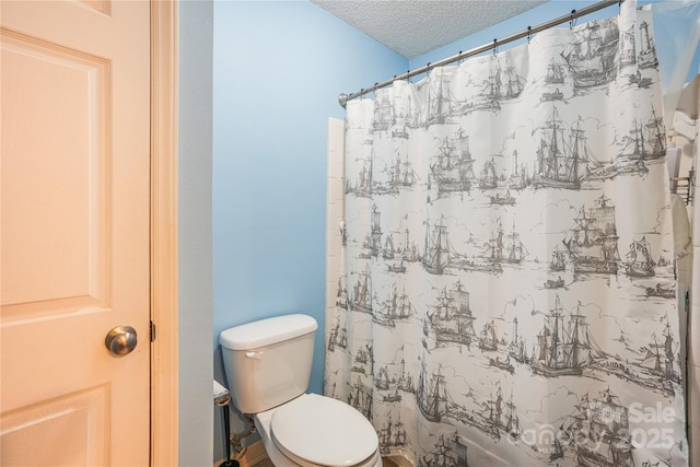 bathroom with a textured ceiling, toilet, and walk in shower