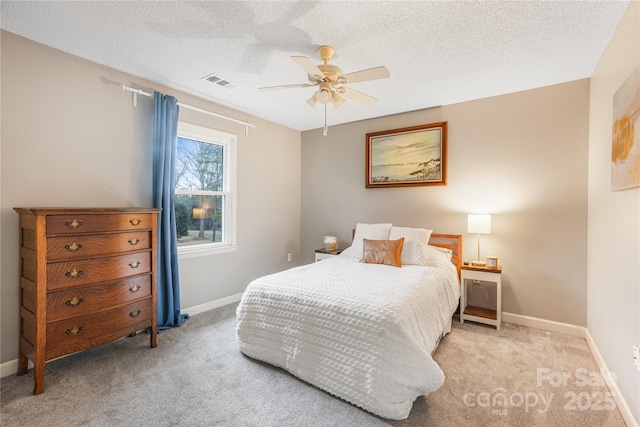 carpeted bedroom featuring ceiling fan and a textured ceiling