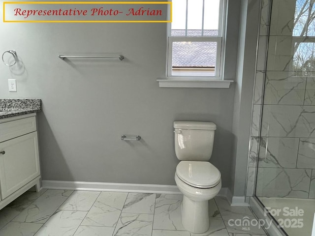 bathroom with tiled shower, vanity, and toilet