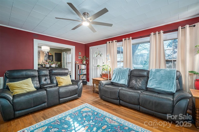 living room featuring hardwood / wood-style flooring, ceiling fan, and ornamental molding