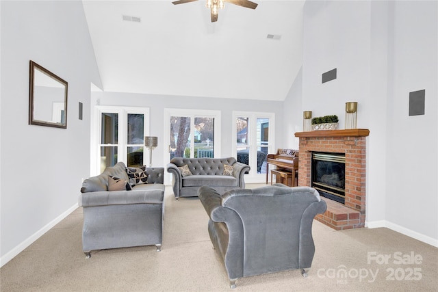 carpeted living room featuring a high ceiling, a brick fireplace, and ceiling fan