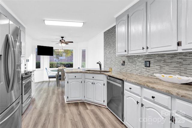 kitchen with kitchen peninsula, white cabinetry, appliances with stainless steel finishes, ceiling fan, and sink