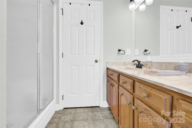 bathroom featuring a shower with door and vanity