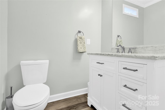 bathroom with toilet, vanity, and hardwood / wood-style floors