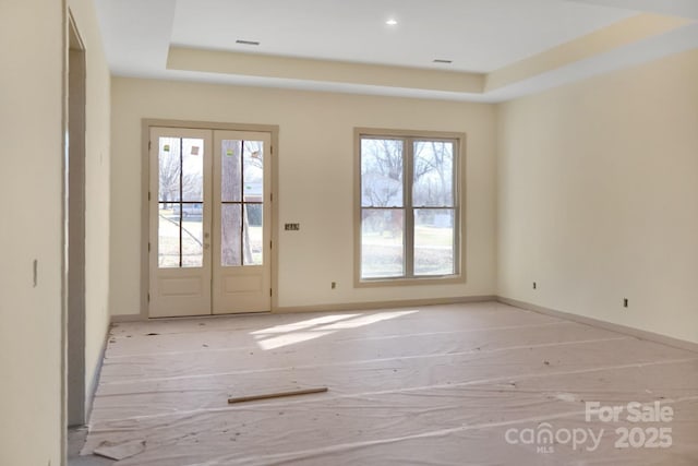 interior space featuring french doors and a tray ceiling