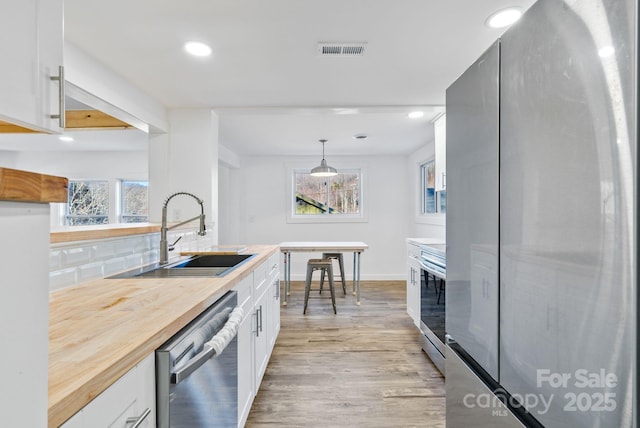 kitchen with appliances with stainless steel finishes, sink, and white cabinetry