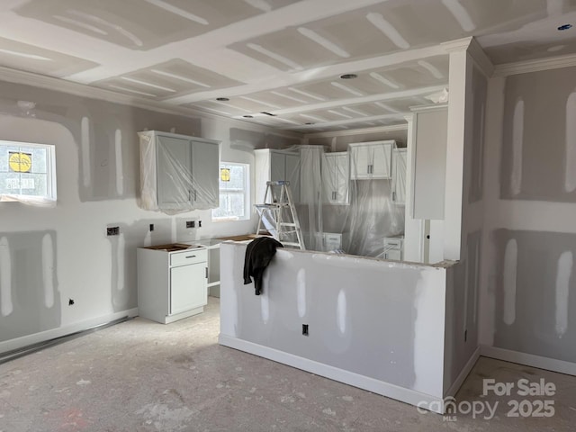 kitchen featuring baseboards and white cabinets