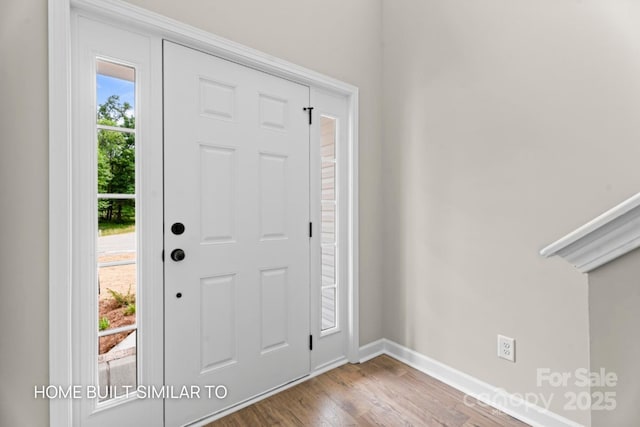 foyer entrance featuring baseboards and wood finished floors