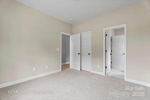 unfurnished bedroom featuring light carpet, a closet, and baseboards