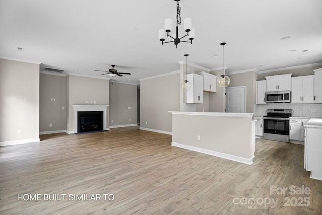 kitchen with white cabinetry, open floor plan, light countertops, appliances with stainless steel finishes, and a center island