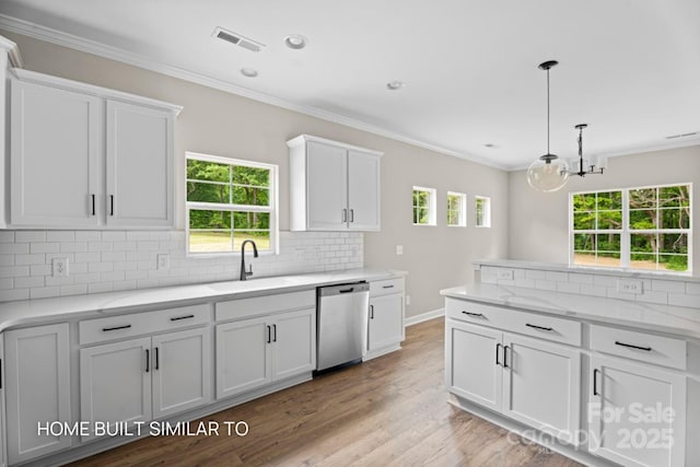 kitchen with stainless steel dishwasher, a sink, white cabinetry, and crown molding