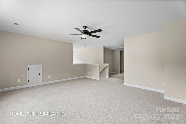 unfurnished room featuring a ceiling fan, light colored carpet, visible vents, and baseboards