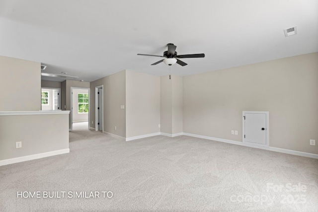 empty room with light carpet, ceiling fan, visible vents, and baseboards