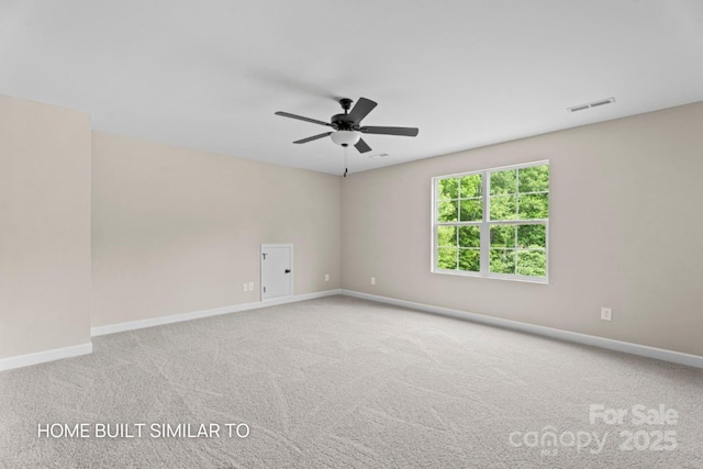 spare room featuring light carpet, visible vents, and baseboards