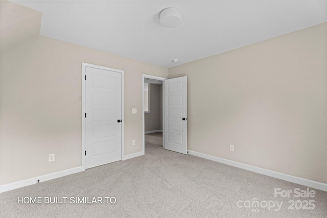 unfurnished bedroom featuring light colored carpet and baseboards