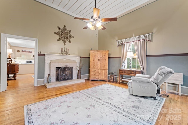 living room with lofted ceiling, light wood-type flooring, and ceiling fan