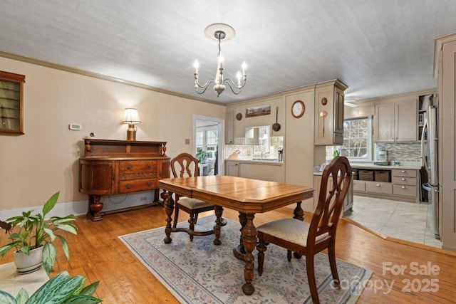 dining space with a chandelier, a healthy amount of sunlight, and light hardwood / wood-style flooring