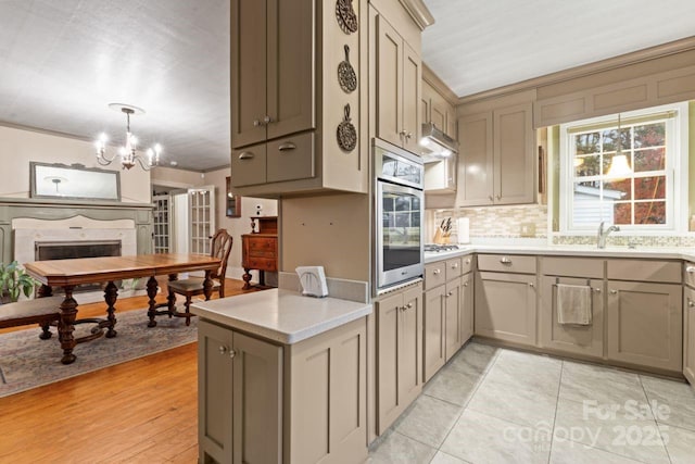 kitchen featuring pendant lighting, stainless steel oven, plenty of natural light, and light tile patterned floors