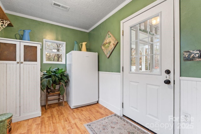 washroom with crown molding, a textured ceiling, and light hardwood / wood-style flooring