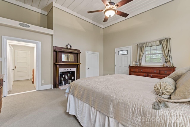 carpeted bedroom with a high ceiling and ceiling fan