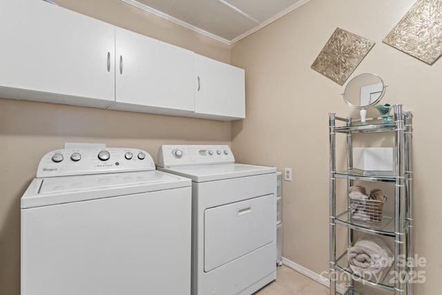 washroom featuring light tile patterned floors, washing machine and dryer, ornamental molding, and cabinets