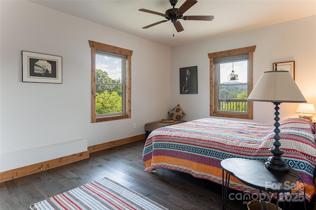 bedroom with ceiling fan, multiple windows, wood finished floors, and baseboards