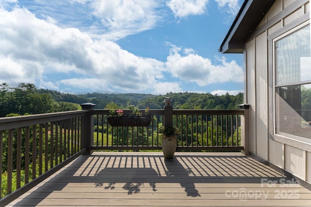 wooden deck with a wooded view