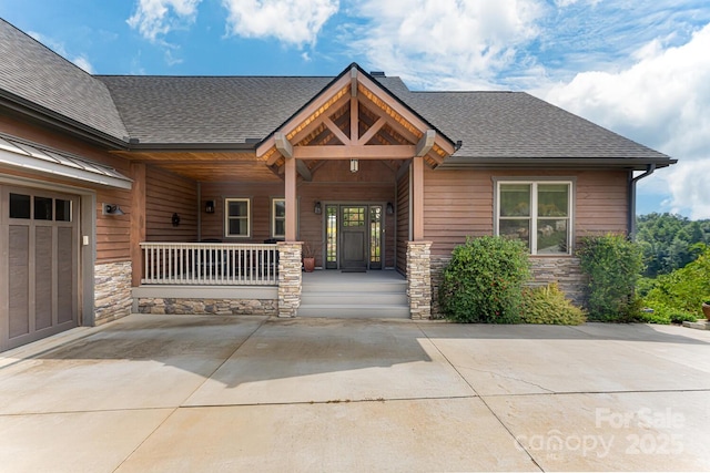 craftsman house featuring stone siding, a porch, and roof with shingles