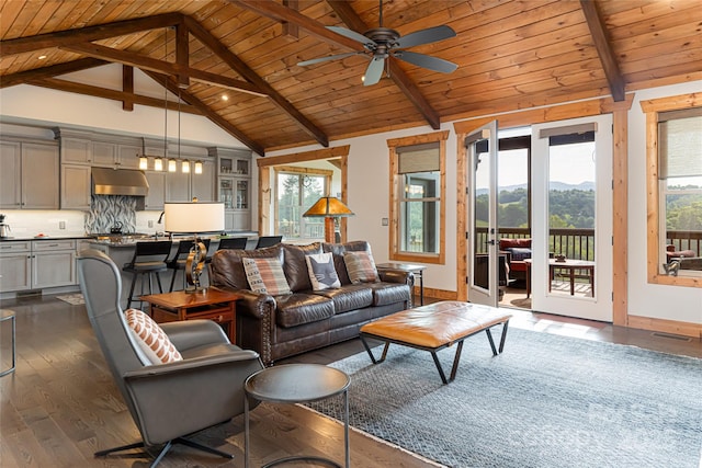 living area with wooden ceiling, a mountain view, dark wood-style flooring, visible vents, and beamed ceiling