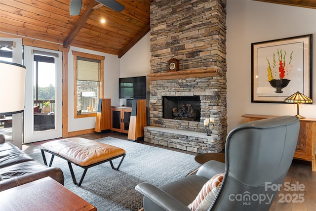 living area featuring ceiling fan, a stone fireplace, wood finished floors, wood ceiling, and beamed ceiling