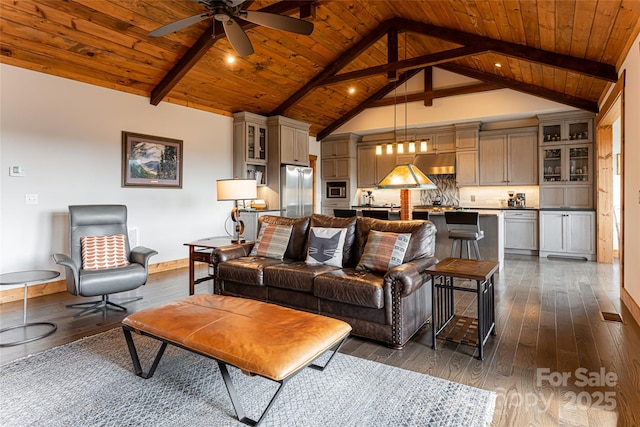 living area with wooden ceiling, dark wood finished floors, beam ceiling, and baseboards