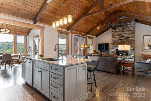 kitchen with vaulted ceiling with beams, wooden ceiling, dark wood-style flooring, and a sink