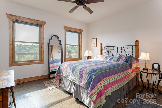 bedroom with ceiling fan, baseboards, and wood finished floors