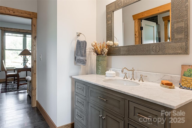 bathroom featuring vanity, baseboards, and wood finished floors