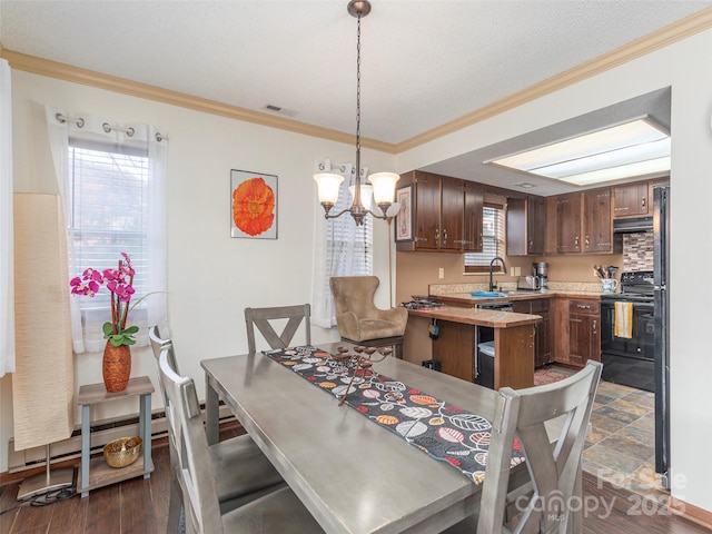 dining space with baseboard heating, crown molding, a chandelier, and sink